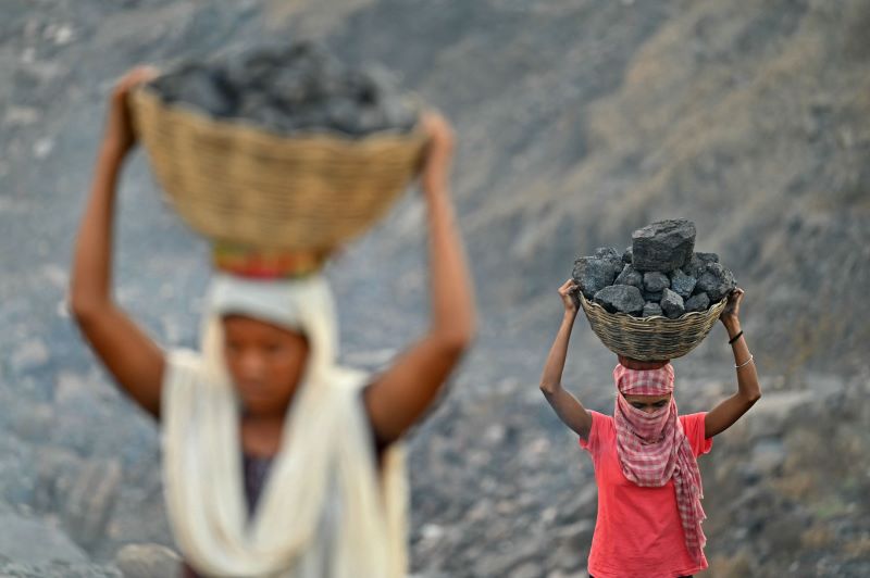 عمال يجمعون الفحم الخام في منجم جاريا بالهند