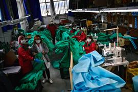 متطوعون في مصنع ملابس يصنعون ملابس لحماية الأطباء من كورونا بإسبانيا