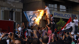 المتظاهرون رفعوا علم مصر على السفارة بعد تحطيم حاجز السفارة الخرسانى