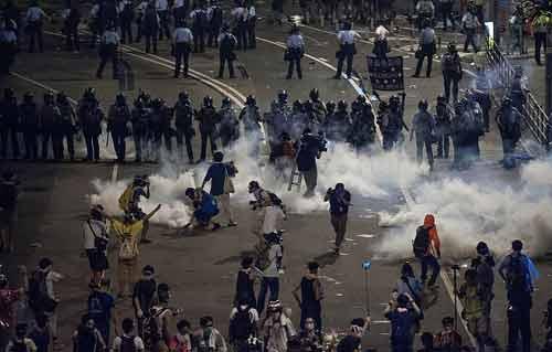 شرطة هونج كونج تستخدم خراطيم المياه لتفريق المحتجين وتطلق للمرة الأولى عيارا ناريا