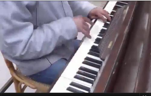 بيانو يتجول في مخيم اليرموك الجائع وصوره مع خلفية من الدمار تنتشر على صفحات السوريين