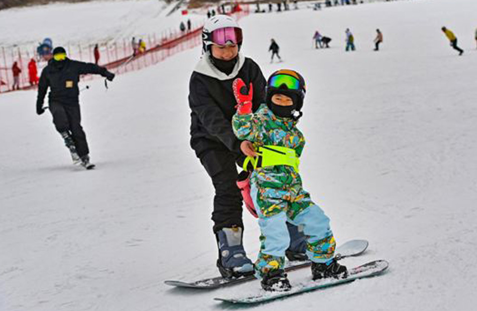 طفل يتدرب على التزلج بمساعدة أمه في منتجع توشان للتزلج في مدينة تشينغتشو بمقاطعة شاندونغ. 