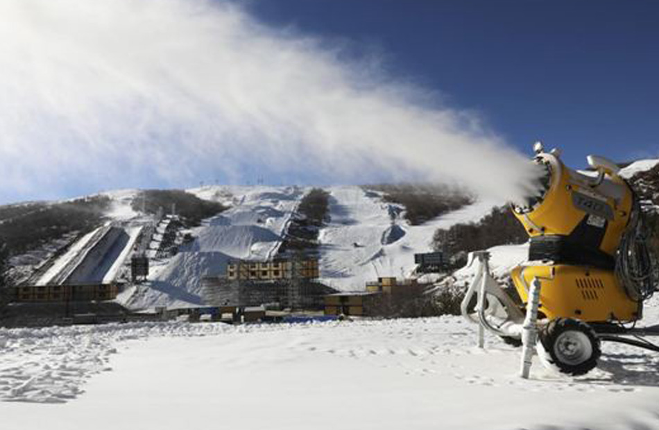 تقوم الآلات بصنع الثلج في حديقة يوندينغ للتزلج في منطقة المنافسة جانغجياكو.