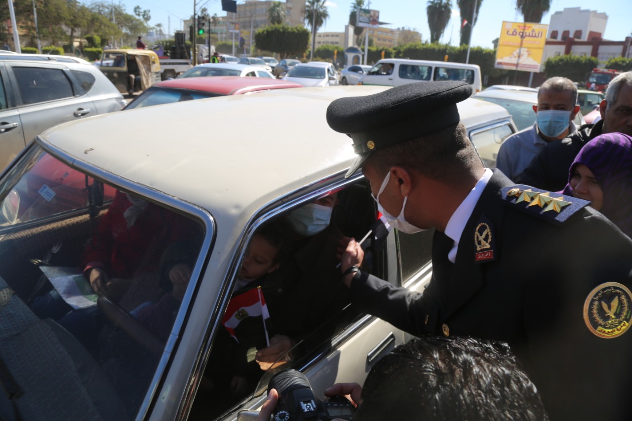 رجال الشرطة يوزعون الحلوى والورد والأعلام على المواطنين والمارة بكفر الشيخ  | صور - بوابة الأهرام